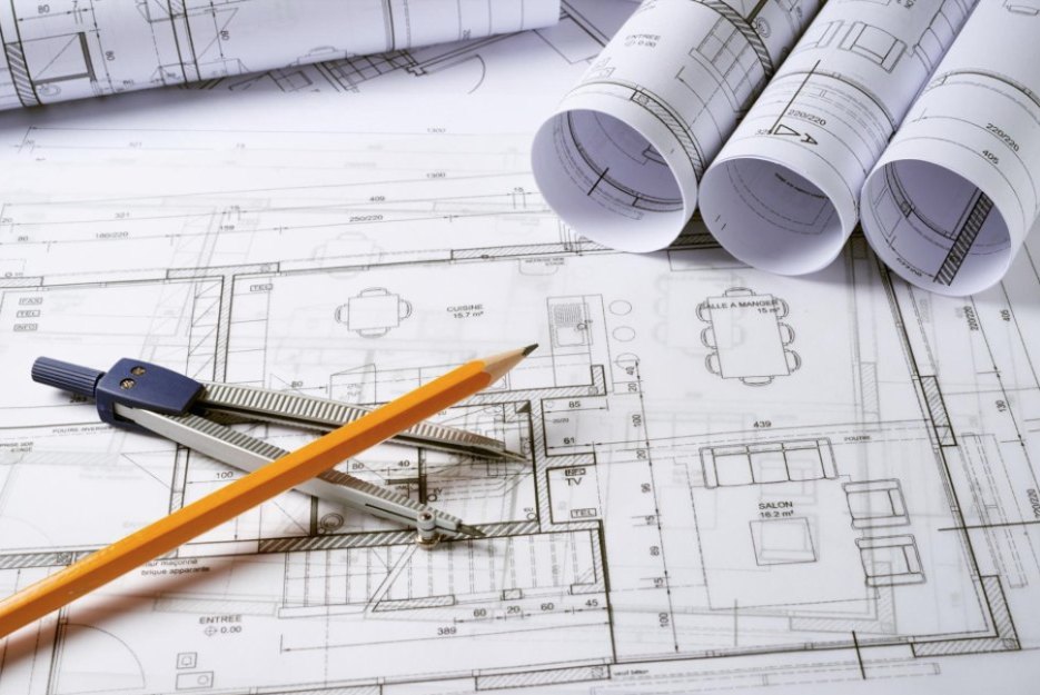 Architectural floor plans with rolled drawing sets, a compass and a pencil laid across them