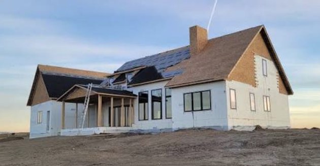 A two-storey ICF home under construction with full-height ICF walls and the roof shingled